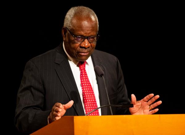 Supreme Court Justice Clarence Thomas speaks at a podium