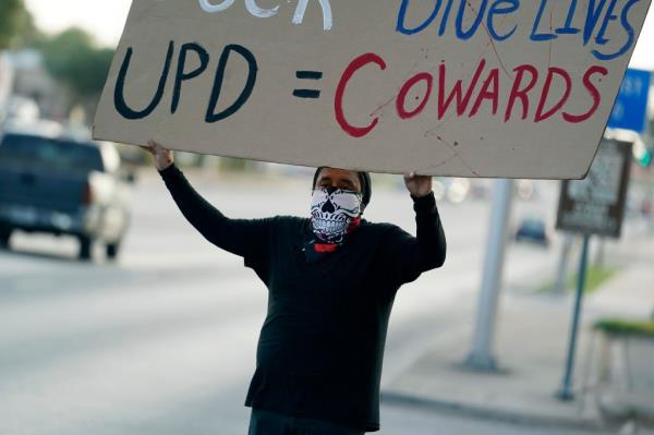 A protester is pictured demo<em></em>nstrating outside of a city council meeting in July